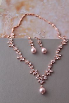 Wedding jewelry set with small pearls Colour- rose  gold tone /clear with rosaline pink pearls Stud earrings. Earrings:approx 3.7 cm  Necklace approx 17 inches(Please note not long necklace!)  All components- rose gold plated over brass , zircon, 10mm  rosaline pink faux pearls. Set of 2 . MORE jewelry: https://www.etsy.com/uk/shop/DonataleAccessories?ref=seller-platform-mcnav&search_query=earrings Matching HAIR accessories: https://www.etsy.com/uk/shop/DonataleAccessories?ref=seller-platform-mcnav&search_query=hair Matching Bridal SASH BELT: https://www.etsy.com/uk/shop/DonataleAccessories?ref=seller-platform-mcnav&search_query=sash In all my shop listing I have made every effort to ensure that the images match the item as closely as possible! However, colours do vary on different monitor Pink Bridal Necklace With Matching Earrings For Wedding, Pink Pearl Bridal Earrings For Wedding, Pink Pearl Wedding Jewelry, Rose Gold Bridal Jewelry Set, Pearl Drop Earrings Wedding, Wedding Earrings Pearl, Mother Of The Bride Jewelry, Pearl Wedding Jewelry Sets, Rose Gold Jewelry Set