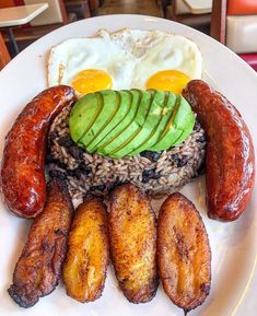 a white plate topped with sausages, rice and an avocado