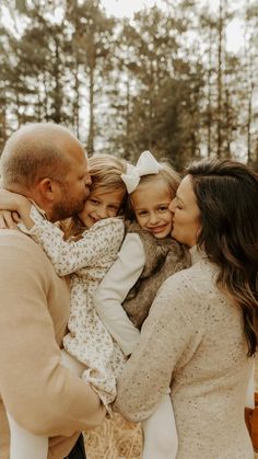 a family hugging each other in the woods