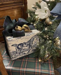 a christmas tree with presents wrapped in blue and white ribbon on it's top