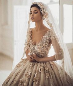 a woman wearing a wedding dress with flowers on the back and veil over her head