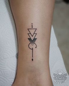 a woman's foot with a small tattoo on the side of her leg and an arrow