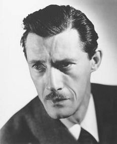 black and white photograph of a man in a suit with a moustache on his face