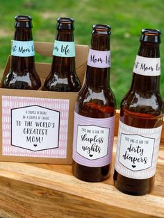 four bottles of beer sitting on top of a wooden table next to a card board