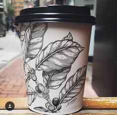 a coffee cup sitting on top of a wooden table next to a brick walkway and sidewalk