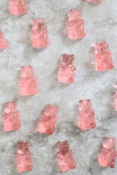 small pink gummy bears on a marble surface