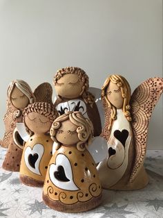 three ceramic angel figurines sitting on top of a table