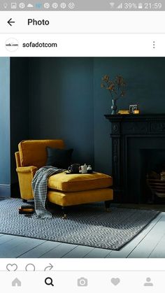 a living room with blue walls and a yellow chair in front of a fire place