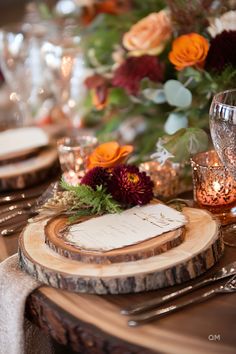 the place setting is set with wooden slices and floral centerpieces, along with silverware