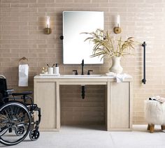 a bathroom with a sink and a wheel chair in front of the mirror on the wall