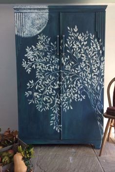 an armoire painted with white flowers and leaves