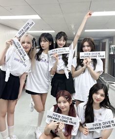 the girls are holding up signs in an office building