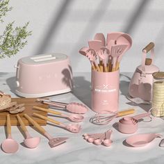 pink kitchen utensils and cooking utensils on a table