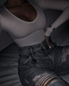 black and white photograph of a woman in ripped jeans with her hand on her hip