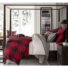 a bed with red and black plaid blankets on it