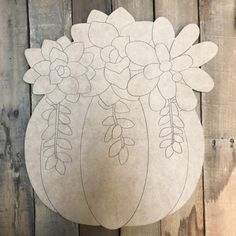 a paper cut out of a vase with flowers in it sitting on a wooden surface