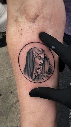 a tattoo on the leg of a person with a woman's face in a circle