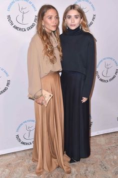 two women standing next to each other on a red carpet