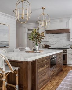 a large kitchen with marble counter tops and wooden cabinetry, along with white cabinets