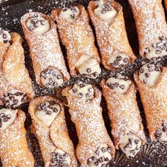 chocolate covered croissants are arranged on a baking sheet with powdered sugar