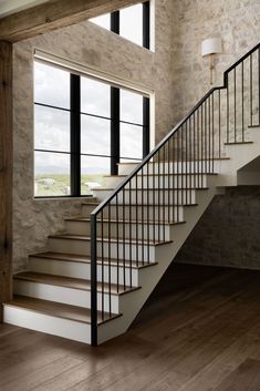 a stair case in front of a window next to a wooden floor