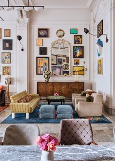 a living room filled with furniture and pictures on the wall