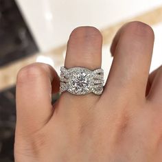 a woman's hand with a diamond ring on top of her finger and an engagement band in the middle