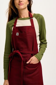 a woman wearing an apron and green sweater