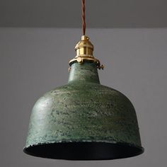 an old green light hanging from a ceiling