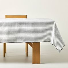 a wooden table with a white and black striped tablecloth on it's top