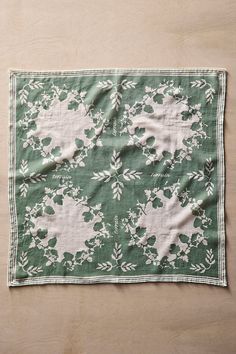 a green and white flowered napkin on a wooden surface