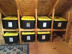 several storage bins in the corner of a room with wood flooring and walls