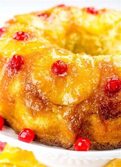 a pineapple upside down cake on a white plate with cranberries around it