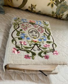 an embroidered book on top of a bed