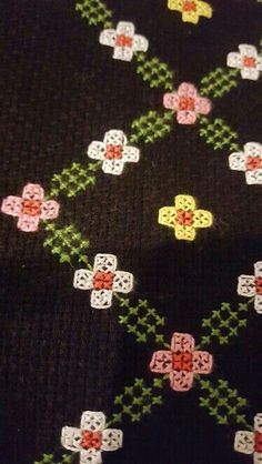 a close up view of a black tie with colorful flowers and crosses on the side