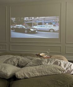 a bedroom with a large screen on the wall