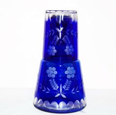 a blue glass vase sitting on top of a white table