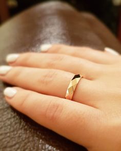 a woman's hand with a gold ring on it