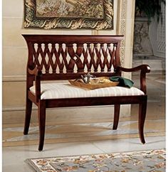 a wooden bench sitting in front of a painting on the wall next to a rug