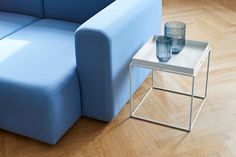 a blue couch sitting next to a table on top of a hard wood floored floor