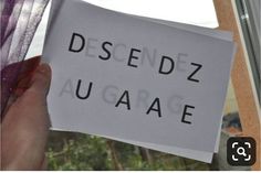 a person holding up a piece of paper with the words desendz augage written on it