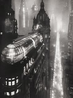 an old black and white photo of a city at night