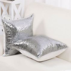 two silver sequin pillows on a white couch