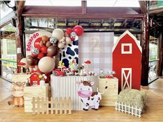 an assortment of farm animals and balloons on display in a room with wooden flooring