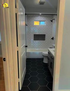 an open door leading to a bathroom with black and white tile