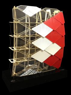 a sculpture made out of metal and wood with red, white and black squares on it