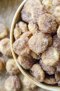 a bowl filled with sugared donuts sitting on top of a table