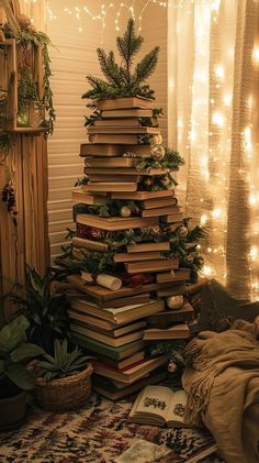 a stack of books sitting on top of a rug next to a christmas tree covered in lights