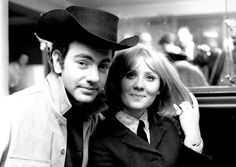 black and white photo of man and woman posing for the camera in front of a bar