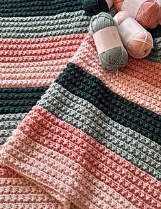 crocheted blanket with balls of yarn on top